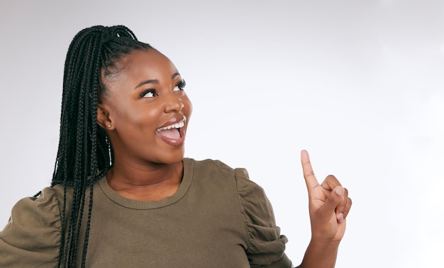 Mockup thinking and black woman pointing at studio background advertising space and wall Happy female model ideas and product placement of marketing promotion announcement and commercial review