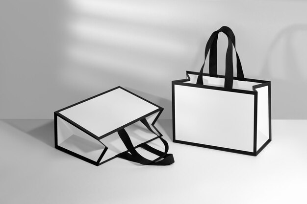 Mockup of a white paper bag with black border and black fabric handles