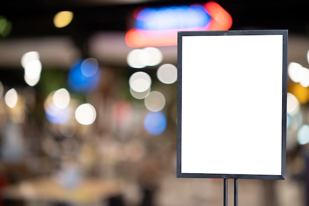 Mockup white poster with black frame stand in front of blur restaurant cafe background for show