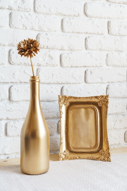 Mockup with a frame and dry flowers in a vase on a white table