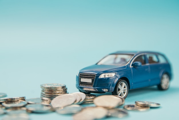 Model blue toy SUV car parking on coins