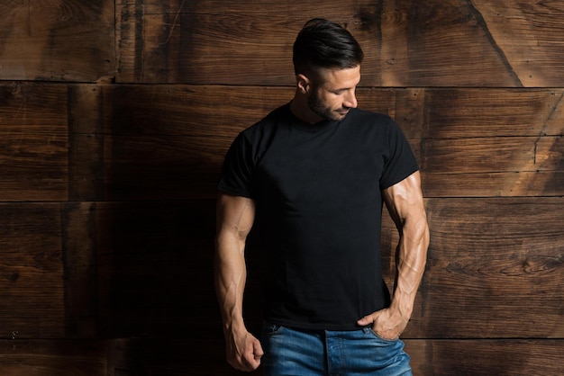 Model Flexing Muscles Near the Wooden Wall