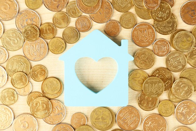 Photo model of house with coins on table close up