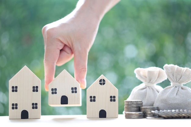 Model house with and money bag on natural green background