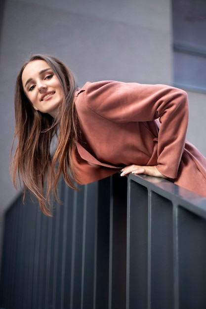 The model looks out from behind the pyrils and laughs Portrait of a smiling girl