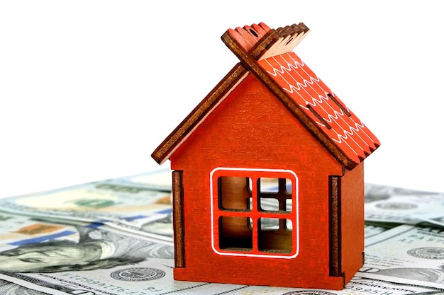 Model of small family house standing on background of dollars banknotes Cut out Selective focus