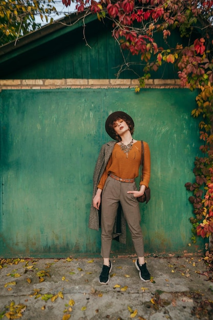 Model in vintage clothes posing on camera backdrop of a country house