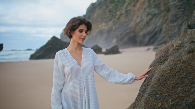 Model walking island shore on cloudy day smiling peaceful traveler enjoying