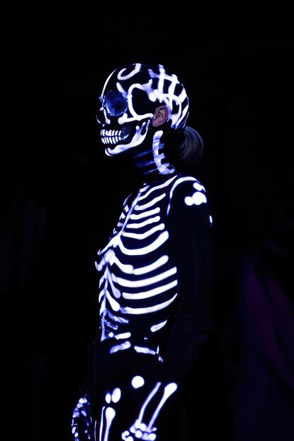 Photo a model wearing a glowing skeleton costume in a dark setting showcasing creative fashion