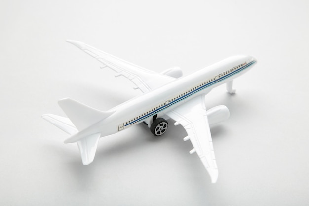 Model white airplane on a grey wall. Travel concept