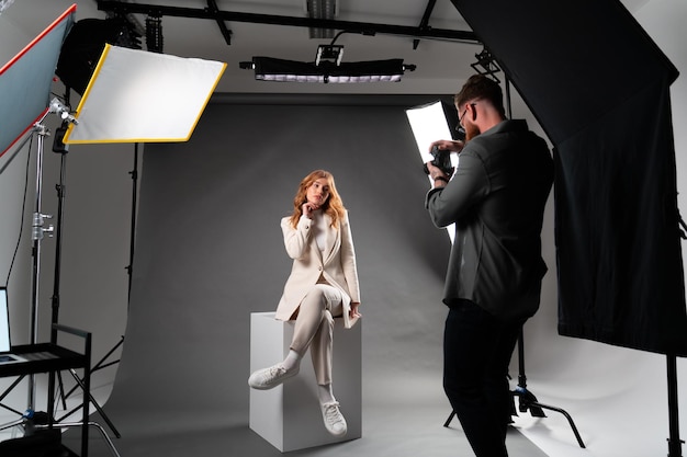 Photo model woman preparing posing for photo taken with professional photographer in studio on fashion