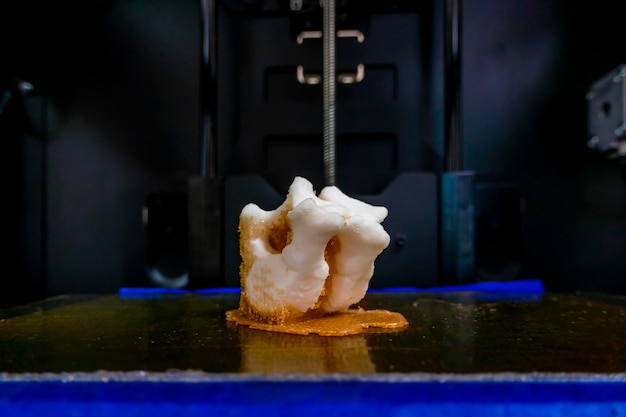 Modern 3D printer printing figure closeup macro 3d printer prints a vertebra