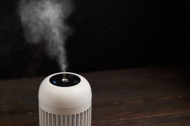 Modern air humidifier on black background