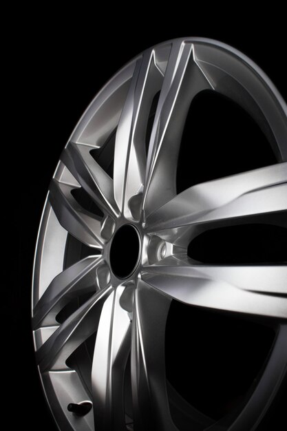 Modern aluminium alloy car rim isolated on black background.