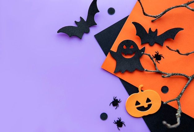 Modern background with bats pumpkins leaves spiders on a violet background Halloween with copy space for text Flat lay top