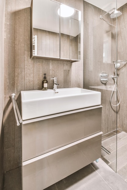 Modern bathroom in gray tones with appropriate equipment in the form of a sink and shower