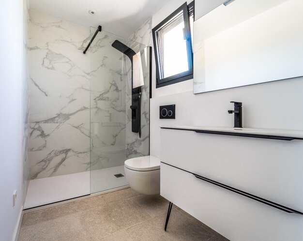 Modern bathroom with a white shower plate with black and white details in country house