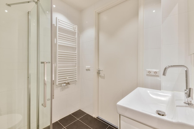 Modern bathroom with white tiled walls and black tiled floor