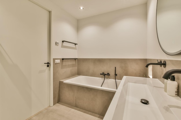 A modern bathroom with white walls and beige tiles on the floor there is a large mirror above the sink