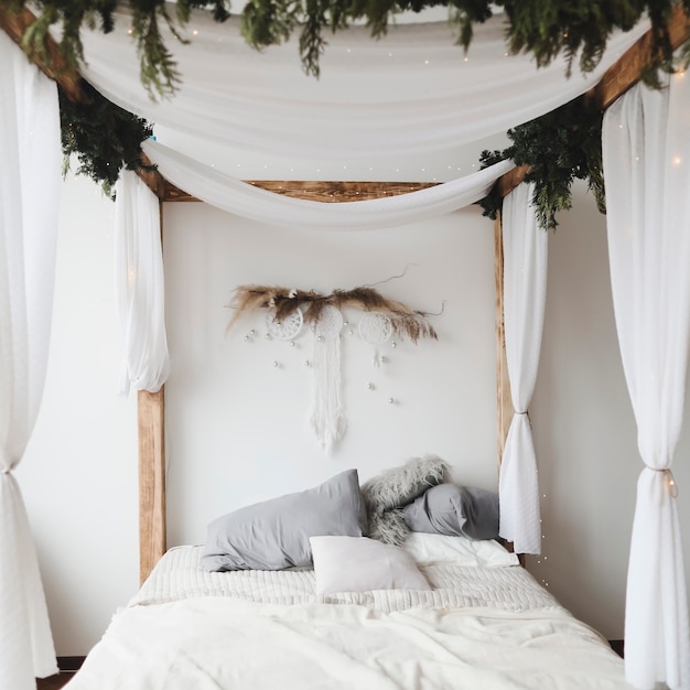 modern bedroom interior in scandinavian style with a cozy bed with wooden canopy and pillows