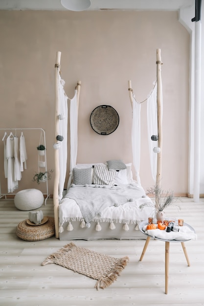 modern bedroom interior with bed with wooden canopy and pillows blanket and a bedside table