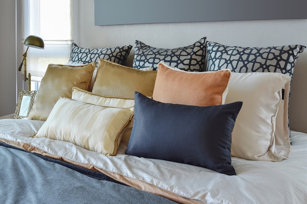 Modern bedroom interior with orange and gold pillows on bed and