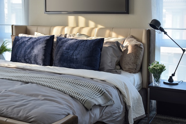 Modern bedroom with blue pillows and black lamp on table