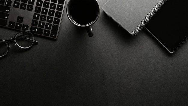 Modern black office desk with office supplies and copy space for presentation background