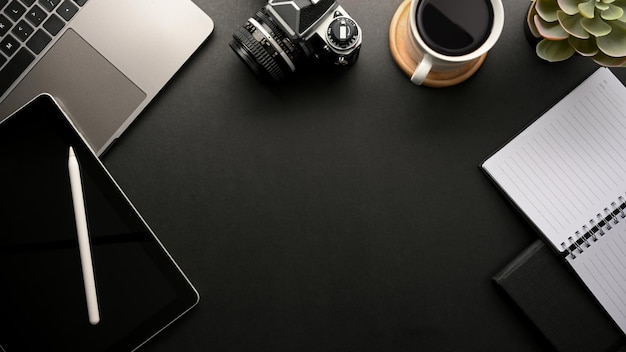 Modern black workspace with a copy space for product display digital devices and supplies Top view