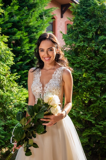 Modern bride in a beautiful dress in sunny day outdoors