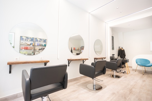 Modern bright beauty salon hair salon interior business with black chairs round mirrors and neon lights