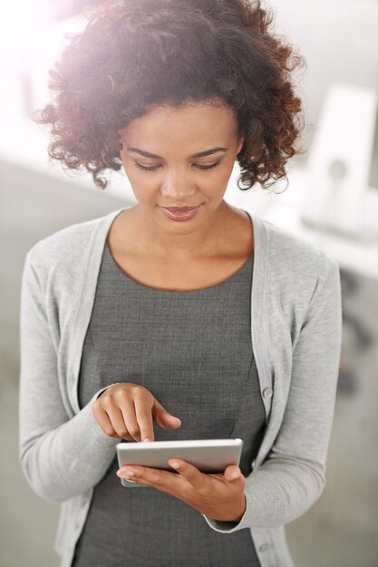 Modern business Cropped shot of a young businesswoman using her tablet in the office