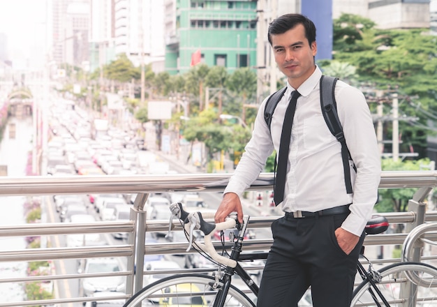 Modern Business man is cycling bicycle to work to avoid traffic jam in busy city