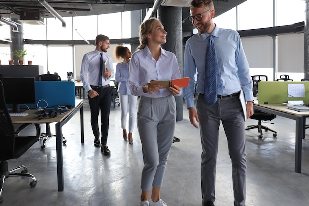 Modern business people have a discussion while walking through the office.