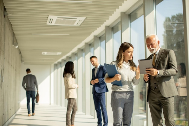 Modern business people using digital tablet in the office corridor