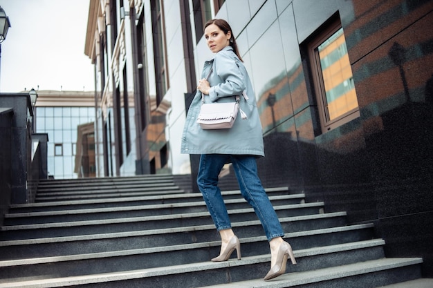 Modern business woman climbs the stairs up near the business building Lifestyle