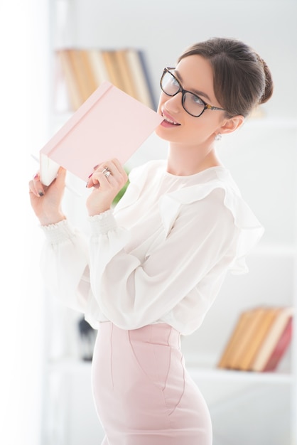 Modern business woman in the office with glasses and with notebook