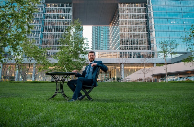 Photo modern businessman using gadget on coffee break business man working at desk in park near office