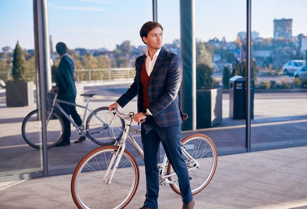 Modern businessman with bike commuting to work