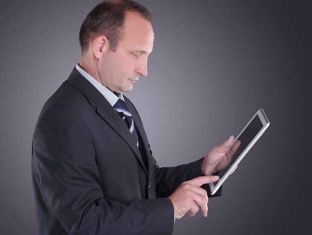 Modern businessman with a digital tabletisolated on black background