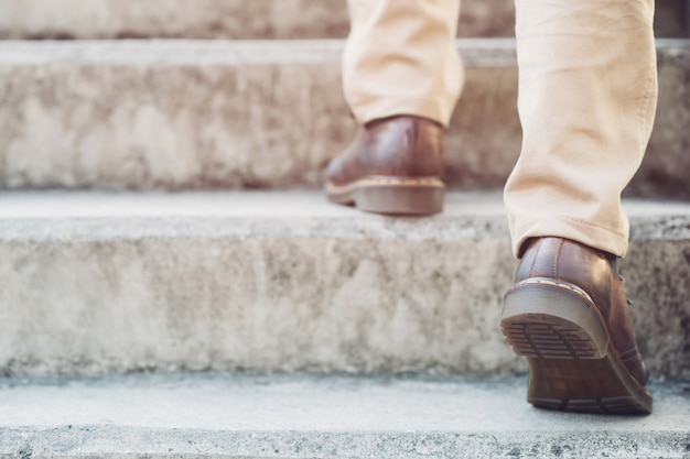 modern businessman working  close-up legs walking up the stairs in modern city. 