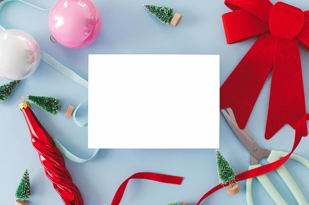 Photo modern christmas card mockup empty card with space for text and decorations on blue paper flat lay