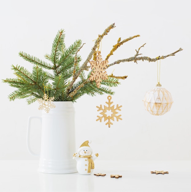 Modern Christmas sill life in jug with snowman on white wall