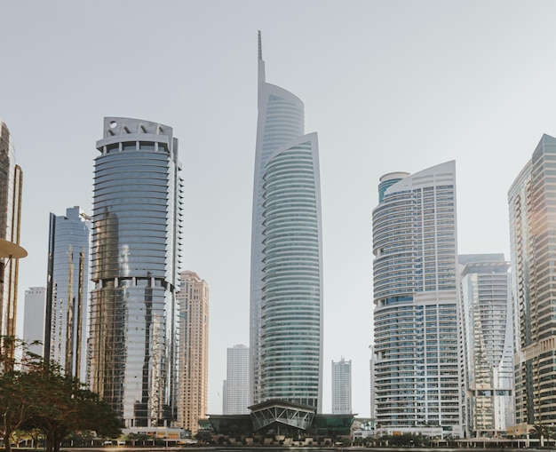 Modern city skyscrapers buildings at sunset time with business and residential towers around a lake