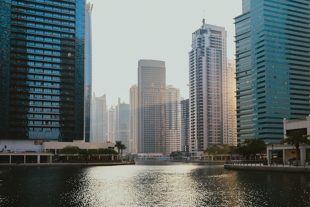 Modern city skyscrapers buildings at sunset time with business and residential towers around a lake