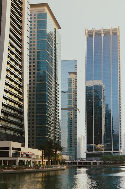 Modern city skyscrapers buildings at sunset time with business and residential towers around a lake