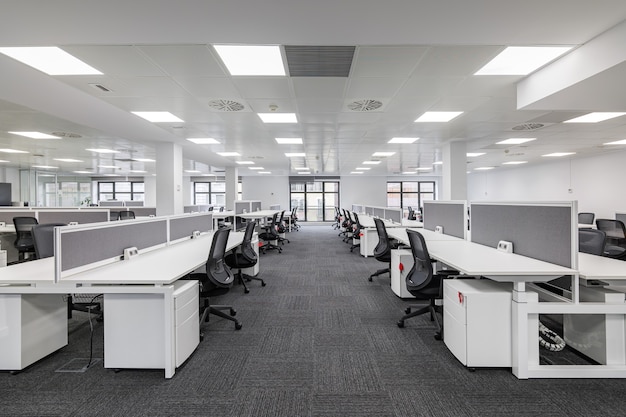 Modern corporate open office in minimalist modern design in whites and greys empty office workstations