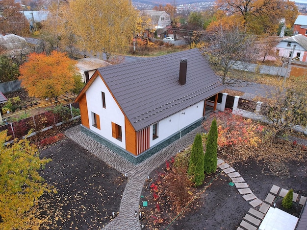 Modern country house in the village in autumn aerial top view