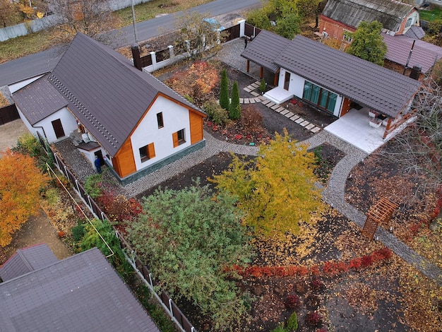 Modern country house in the village in autumn aerial top view