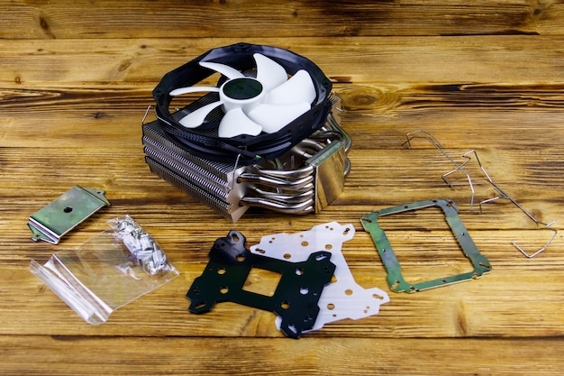 Modern CPU cooler with installation kit on a wooden desk